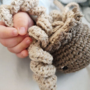 Bebé sujetando medusa de crochet