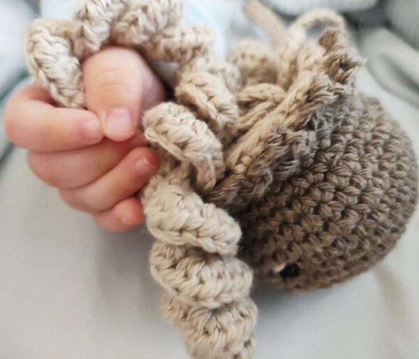 Bebé sujetando medusa de crochet