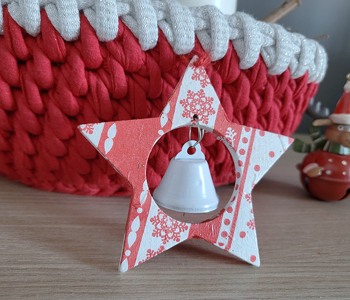 Estrella de madera decorada con servilleta de navidad. Detalle de cesto de trapillo rojo